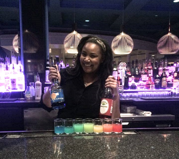Bartender with rainbow shots at a professional bar setup